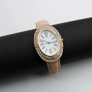 Detail of oval rhinestone bezel watch with blue hands and pink crocodile leather strap