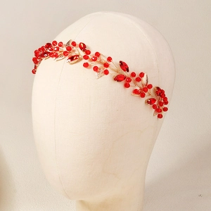 Handmade gold bridal headband with red crystals and leaf-shaped gemstones for weddings
