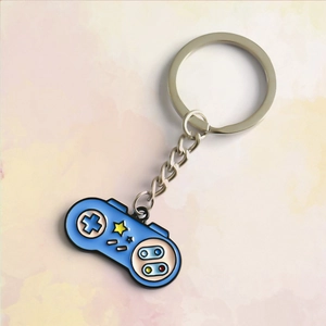 Close-up of retro blue game controller keychain with enamel detail and silver metal ring