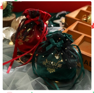 Detail of red and green velvet Christmas gift bags with gold Merry Christmas lettering