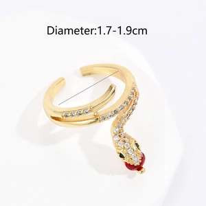 Detail of snake-shaped gold ring with green gem eyes and red waterdrop stone