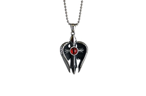 Détail du pendentif croix en acier avec ailes d'ange et pierre œil de démon rouge vintage