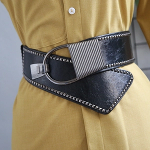 Detail of black punk waist belt featuring silver square rivets and metal D-ring buckle