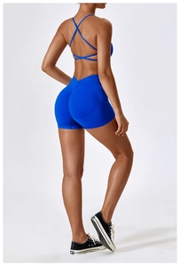 Detail view of royal blue sports bra with criss-cross back and V-waist fitness shorts
