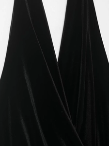 Detail shot of black velvet dress featuring a deep V-neck and elegant draped texture