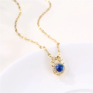 Golden reindeer necklace with blue color-changing zircon pendant on a white background