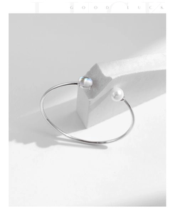 Detail of S925 sterling silver open bangle with white pearl and moonstone on stone