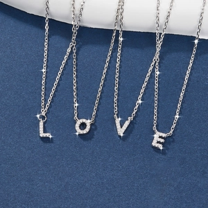 Detail of silver S925 necklaces with crystal-encrusted L, O, V, E letter pendants