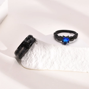 Detail of titanium black ring set with blue heart stone and pavé band on white stone