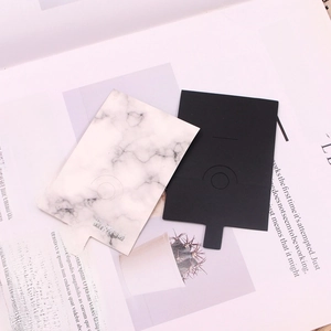Detail view of marble pattern and matte black jewelry display cards on a magazine background
