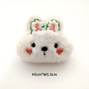 Detail of a white plush rabbit patch with soft faux fur and embroidery, 5cm by 5.5cm size
