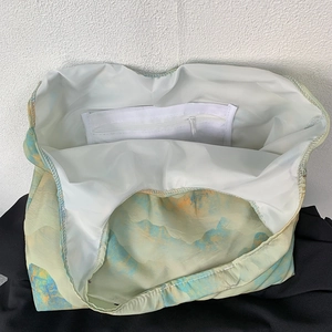 Detail of canvas tote bag interior with open pocket and secure zipper compartment