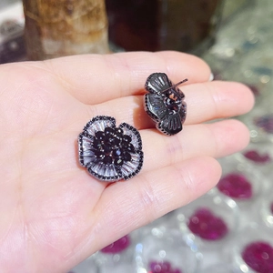Detailed close-up of camellia stud earring featuring black and white cubic zirconia crystals