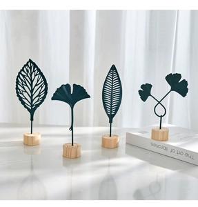 Set of four Nordic black iron leaf ornaments with natural wooden bases for home decor