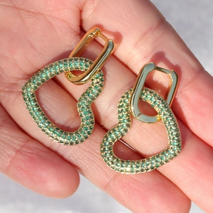 Dettaglio di orecchini placcati oro 18K con ciondolo a cuore e zircone verde