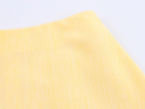 Detailed macro shot of yellow cotton-linen fabric texture with distinct woven pattern