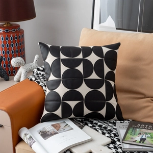Detail of modern beige woven and black leather geometric pillow on luxury sofa