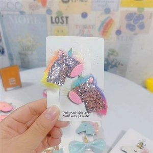 Detail view of 2-piece glitter unicorn hair clips with pink and rainbow plush mane
