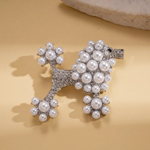 Exquisite pearl and diamond poodle brooch with silver base on warm beige leather