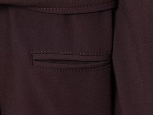Detailed close-up of dark brown blazer fabric texture and reinforced pocket stitching