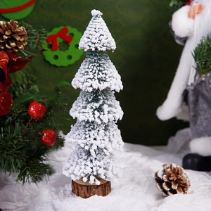 Detailed view of mini Christmas tree with artificial snow and natural wooden base decoration