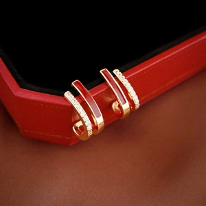 Macro shot of double-row J-hoop earrings with red enamel and pavé cubic zirconia