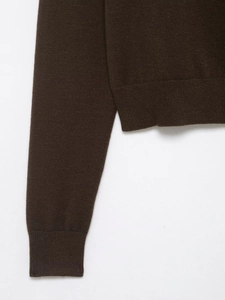 Detail view of dark brown knit cardigan showing ribbed cuffs and fine stitching texture