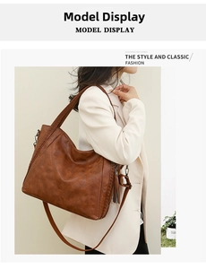 Brown soft leather tote bag with braided edges and tassel detail worn by a model