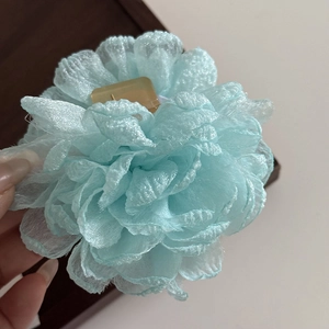 Macro shot of light blue organza rose hair claw clip for a delicate holiday hair look