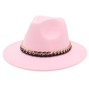 Detail of pink fedora hat featuring a decorative gold chain and black braided band