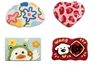 Close-up of thick flocked bathroom mats featuring floral, leopard heart, and duck patterns