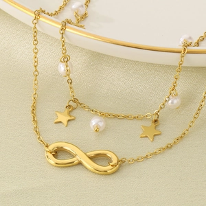 Détail de la chevillère double en acier doré 18K avec pendentifs infini et étoile