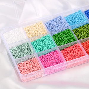 Assorted colorful glass seed beads in a transparent organizer box for DIY jewelry