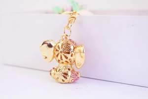 Macro view of gold elephant keychain with pink rhinestones and hollow-out carving