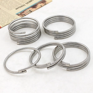 Detailed macro view of five silver multi-coil spiral stainless steel spring bracelets