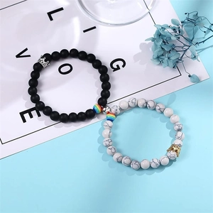 Detail of magnetic couple bracelets with crown charms and natural stone beads
