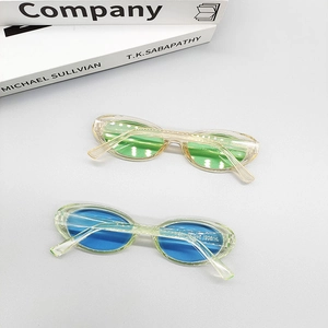 Oval fashion sunglasses with transparent frames and colored lenses in a modern setup