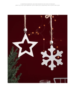 Close-up of white wooden star and snowflake ornaments with hemp rope hanging on red background