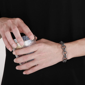 Detail of silver vintage O-chain bracelet with textured round links worn by a model