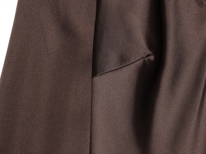 Gros plan sur un tissu satiné marron foncé montrant la texture et les coutures fines