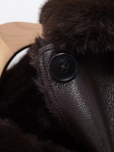 Detailed macro shot of dark brown faux shearling leather jacket with button closure