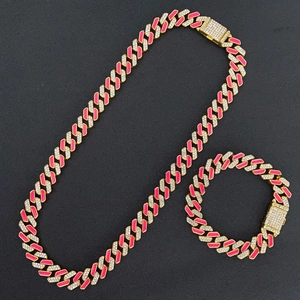 Detail of gold Cuban link chain and bracelet set with pink enamel and crystals