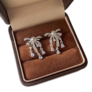 Silver needle pearl zircon drop earrings with bow tassel design on velvet jewelry box
