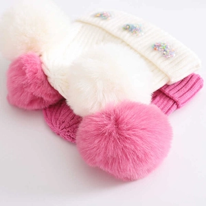 Winter baby knit hats in pink and white with dual pom-poms and cute heart patterns