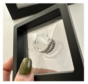 Primer plano de anillo curvado de plata S925 en estuche de exhibición flotante negro