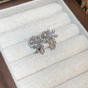 Macro view of snowflake clip-on earrings with sparkling crystals in a velvet jewelry box