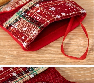 Close-up of red burlap Christmas stocking with snowflake print and plaid pattern detail