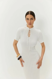 Dettaglio dell'abito bianco in maglia traforata con scollo a balze e laccetti sottili