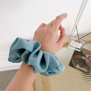 French style light blue satin oversized scrunchie worn on wrist for elegant styling