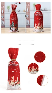 Detail of red Christmas wine bottle cover with Merry Christmas print and gold drawstring